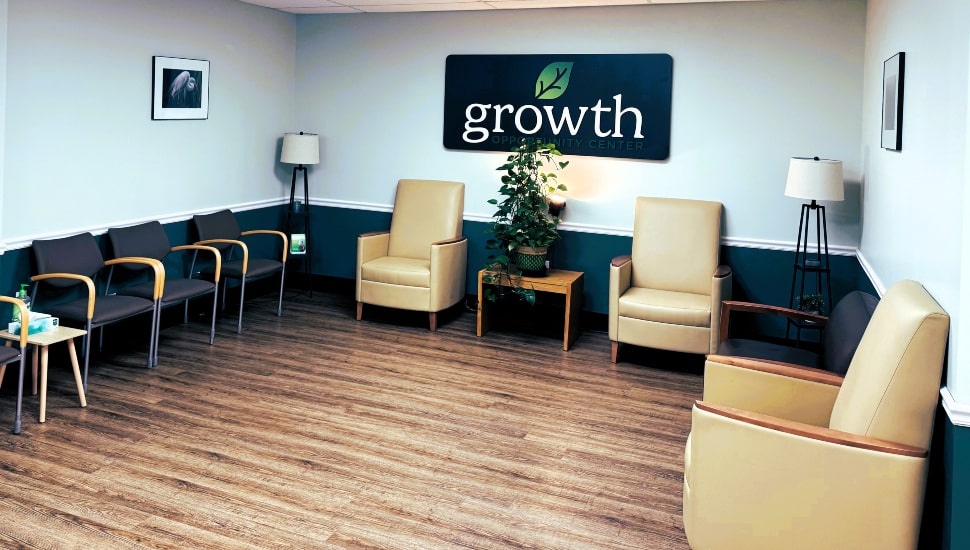 Doctor's office lobby with wood floor and brown chairs.