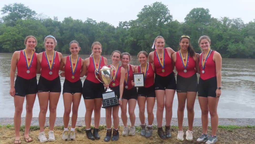 The varsity ladies of the Gwynedd Mercy Academy Crew holding a trophy.