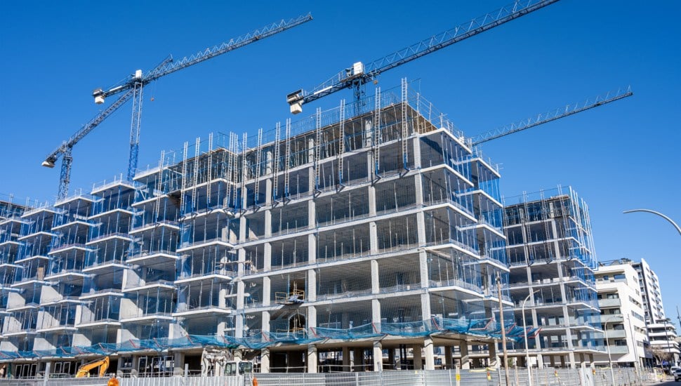 Cranes hover over a multifamily home development.
