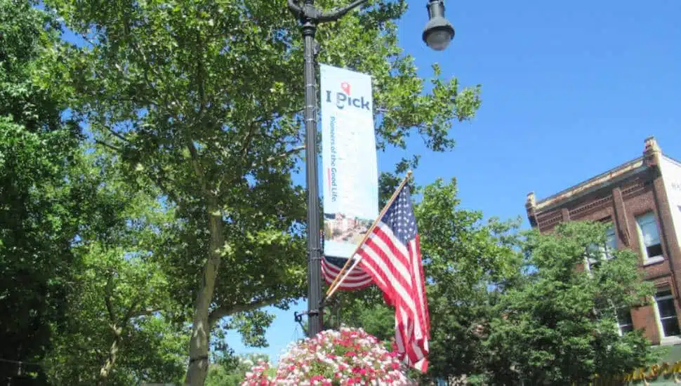 An IPickPottstown hangs on a streetlight over a potted plant in Pottstown.