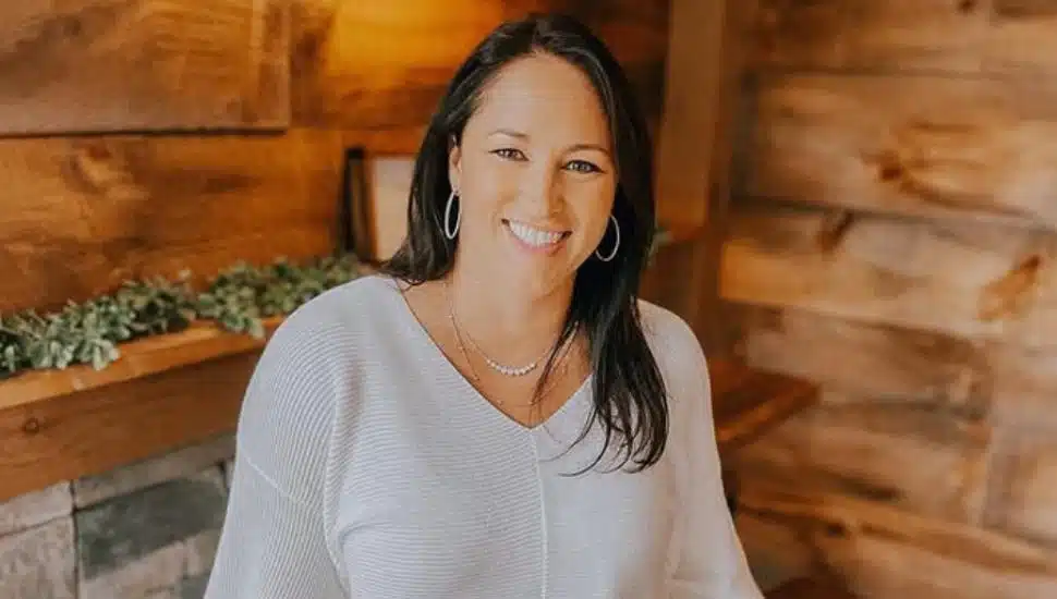 Kathy Romano smiles in a white sweater.