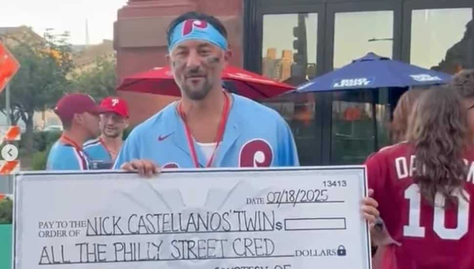 Ambler's Michael Penna holding up a large check after winning a Nick Castellanos look-alike competition.