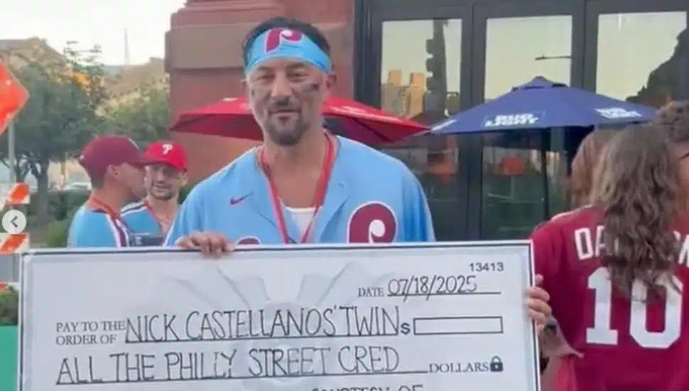 Ambler's Michael Penna holding up a large check after winning a Nick Castellanos look-alike competition.