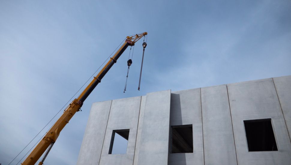 A crane lifts a modular construction unit.