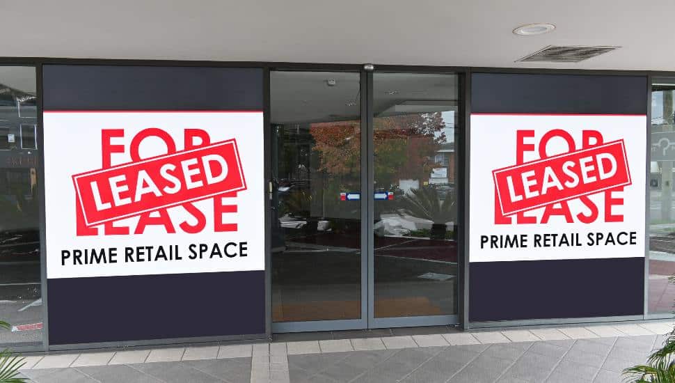 A retail space with For Sale/ Leased sign in the window.