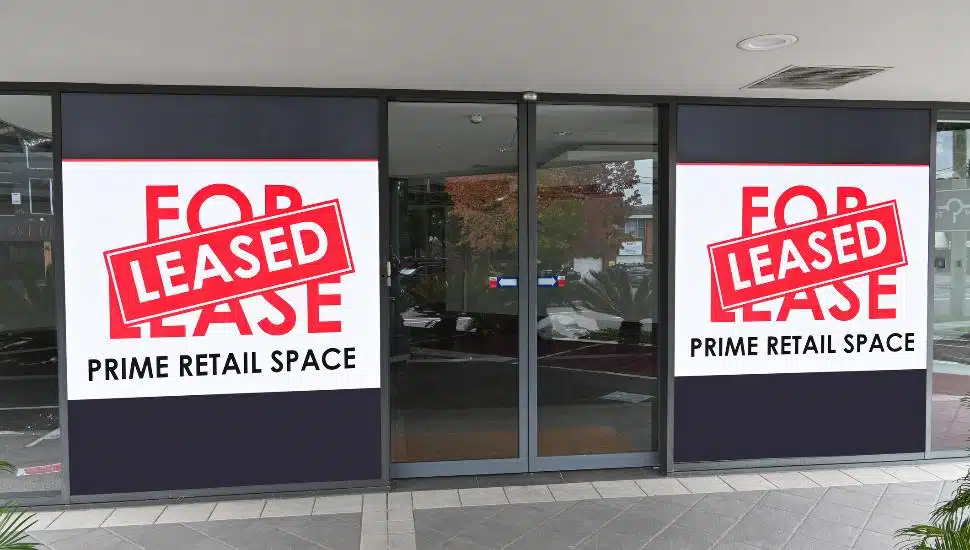 A retail space with For Sale/ Leased sign in the window.