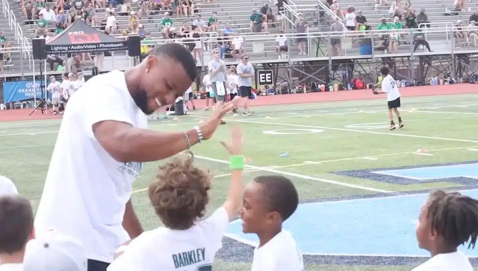 Saquon Barkley high gives kids at his football camp at North Penn High School.