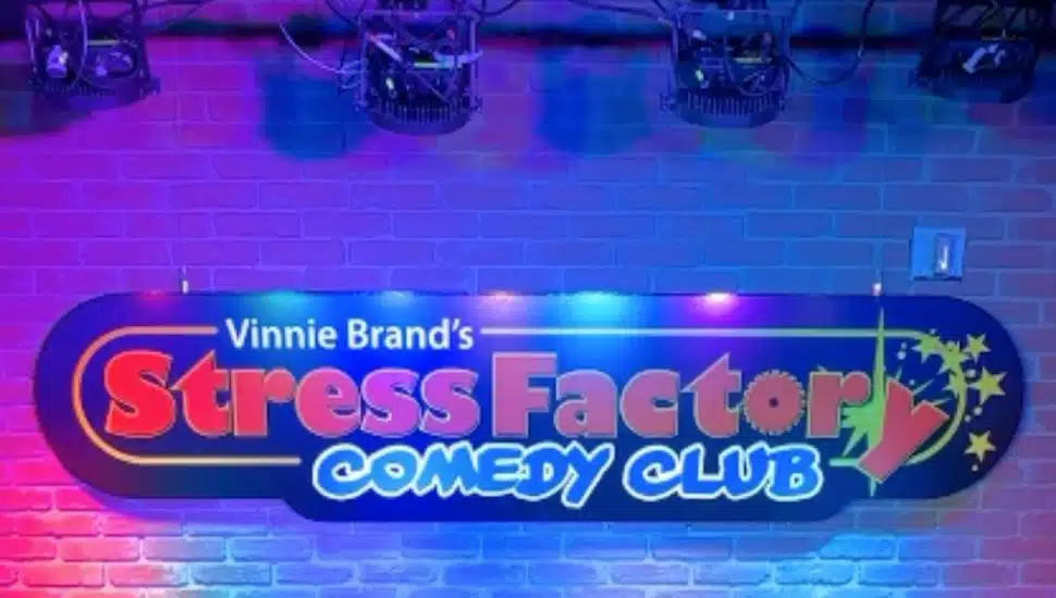 Vinnie Brand's Stress Factory Comedy Club sign on stage.