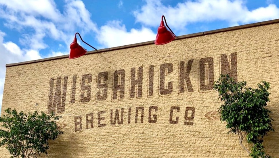 'Wissahickon Brewing' painted on a yellow brick wall.