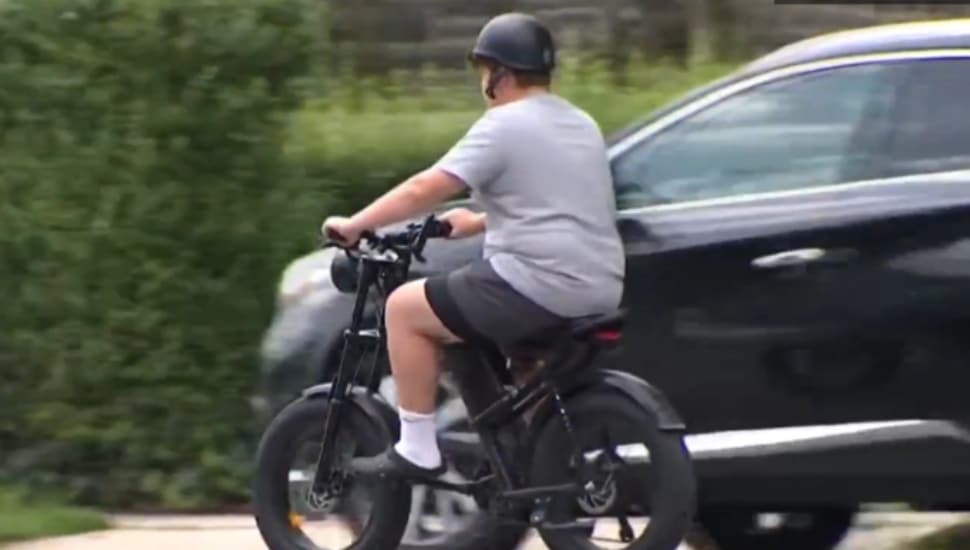 A boy rides an electric scooter.