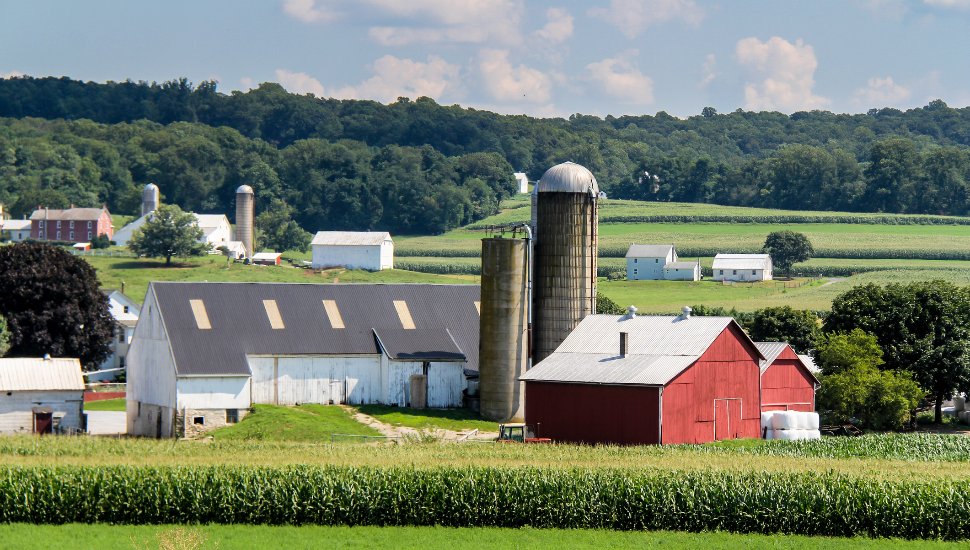 Red barn and silo in distance at a farm in Lancaster County.