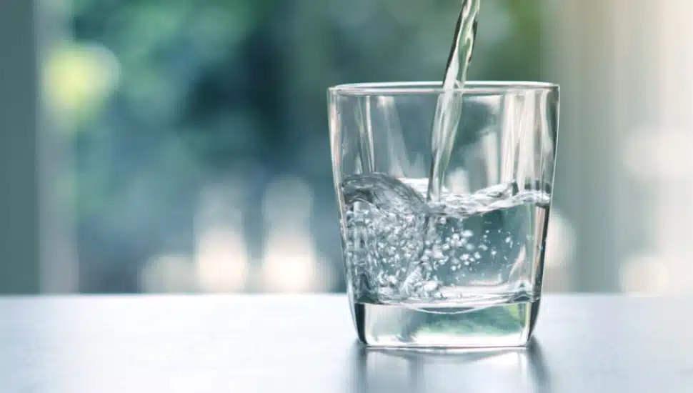 Close up pouring purified fresh drink water.