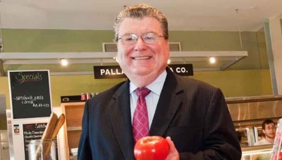 Dr. John L. Stanton Jr. holds an apple.