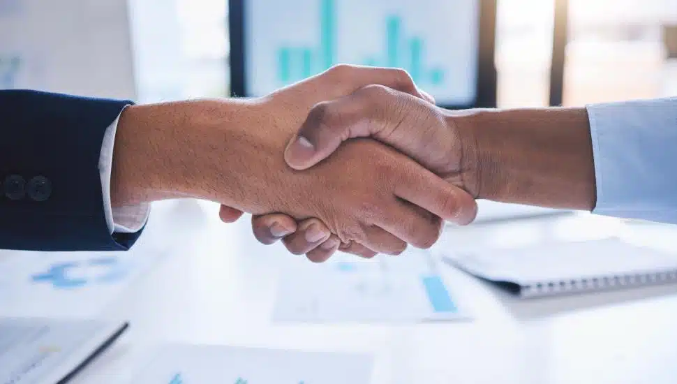 Two professionals shake hands over an acquisition.