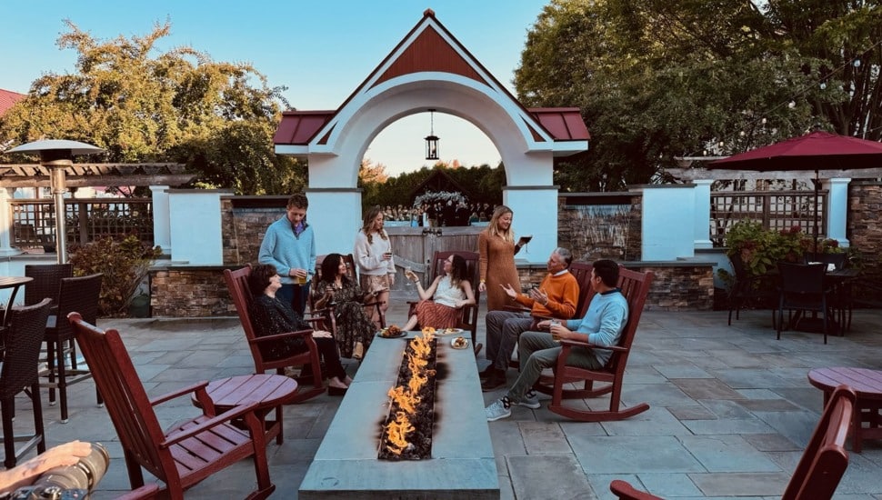 People relax and drink wine outside at a retreat.