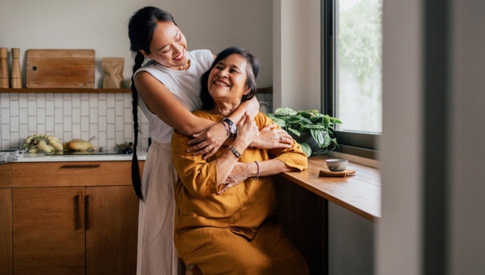 Young woman hugs her elderly mother.