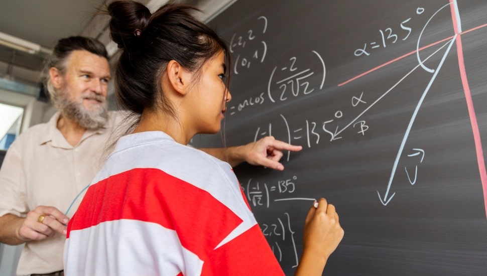 Teacher and student at chalkboard.
