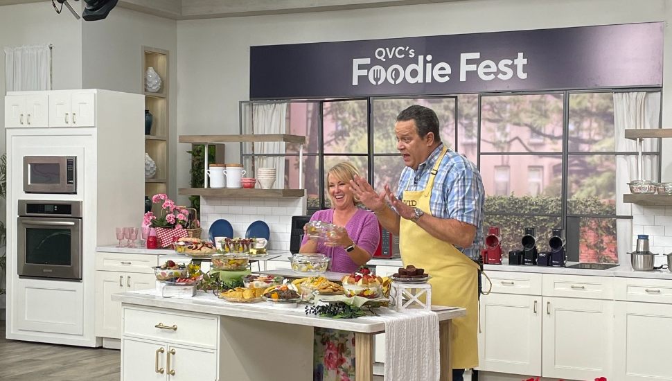 Two hosts filming in a kitchen for QVC.