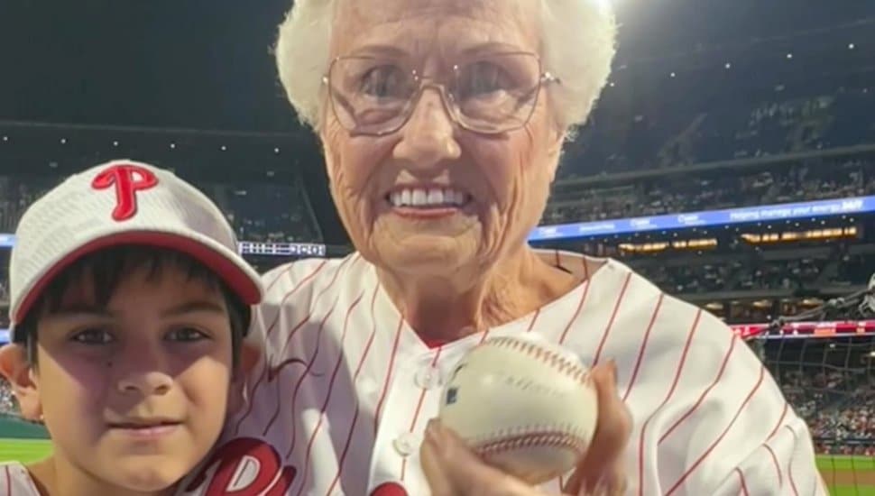 Donna Morey holds the caught baseball at the Phillies game with Jameson Pennings.