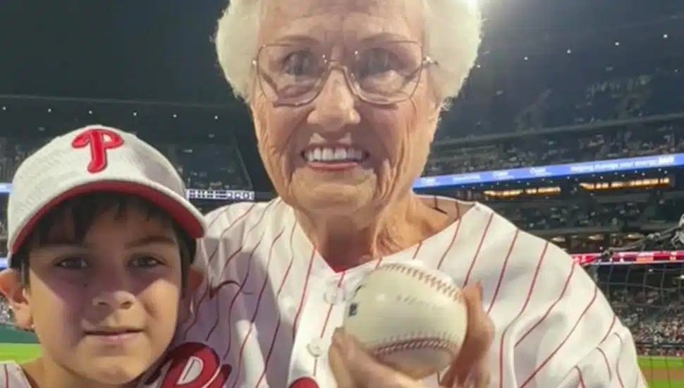 Donna Morey holds the caught baseball at the Phillies game with Jameson Pennings.