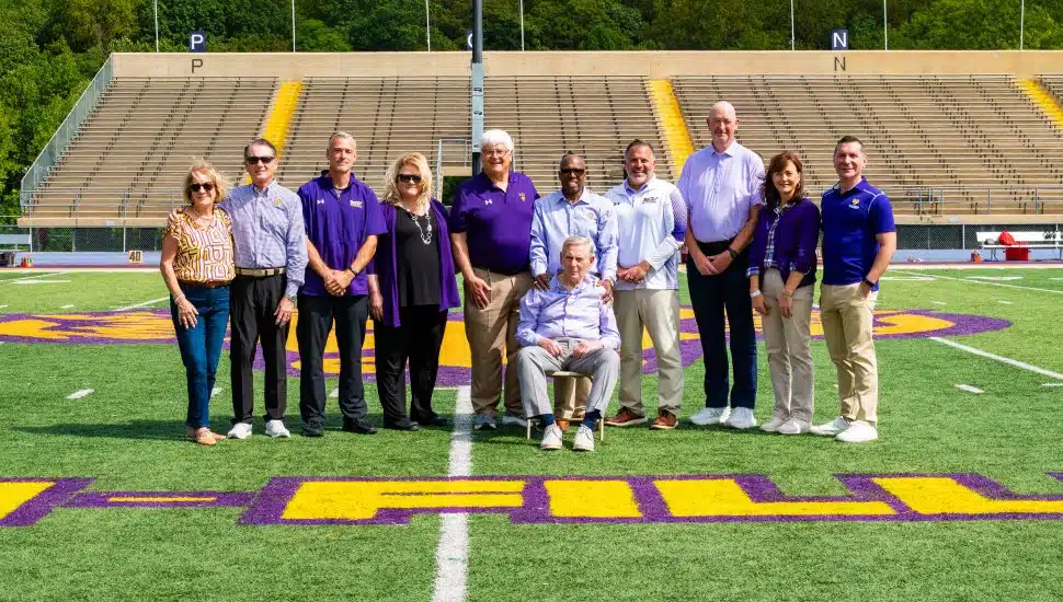 (L to R) Pictured on Tomlinson-Fillippo Field are Agnes Ware, Roger Ware ’82, Head Football Coach Duke Greco, West Chester University President Dr. Laurie Bernotsky, Robert “Tommy” Tomlinson ’70, Tom Fillippo ’69 (sitting), Vice President for University Advancement and External Affairs Dr. Zebulun Davenport, Vice President of University Affairs and Chief of Staff Andrew Lehman, Director of Athletics Terry Beattie, Executive Director of the West Chester University Foundation Deb Cornelius, and Interim President of Commonwealth University Dr. Jeffery Osgood, Jr.