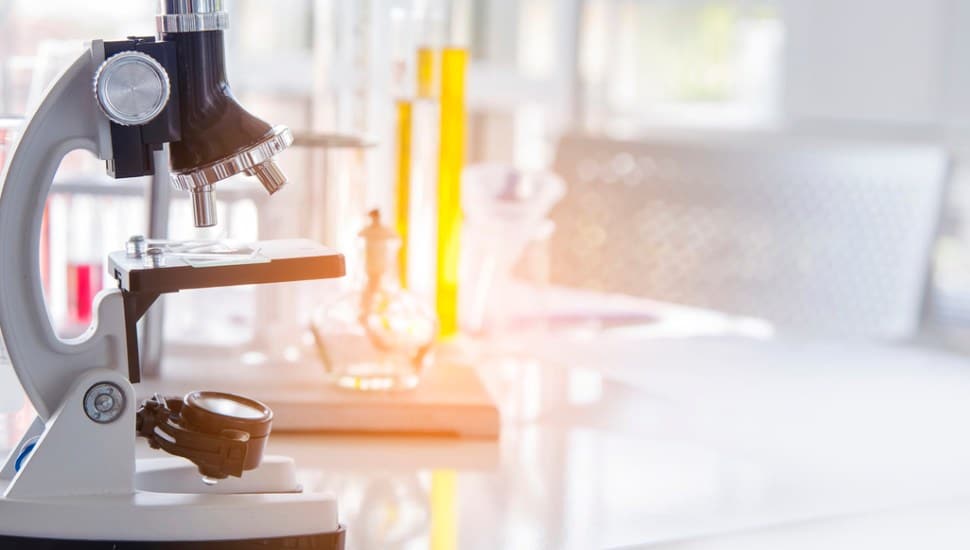 Scientific experiment Microscope on Lab table microbiology equipment.