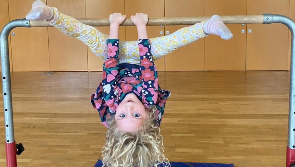 A young girl plays on gymnastics equipment at National Kids Gym.