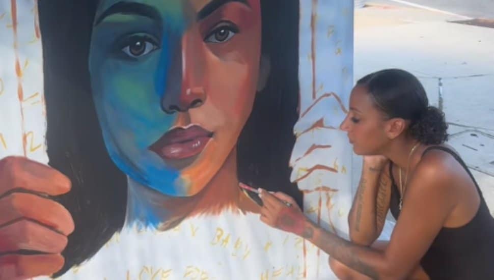 Artist Neasie Blaze paints a portrait in downtown Norristown.