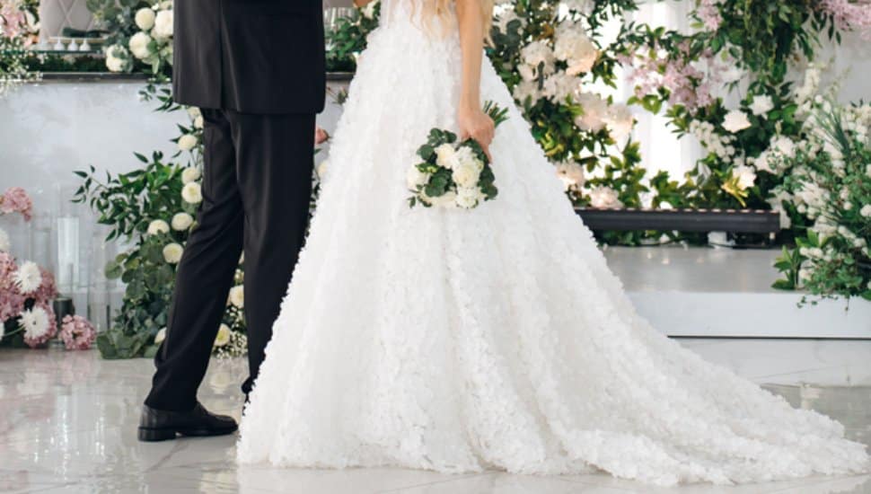 A groom and bride embrace at the altar.