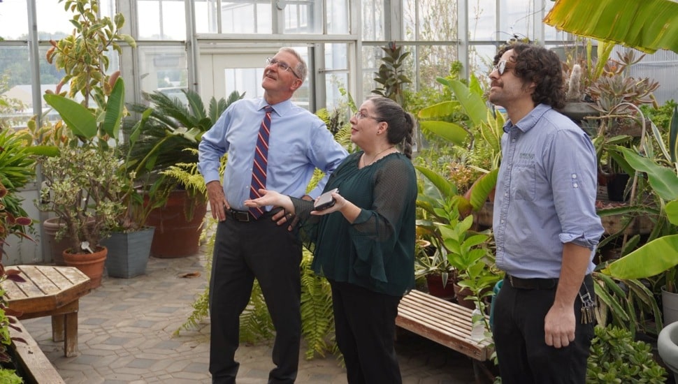 Politician visits greenhouse on college campus.