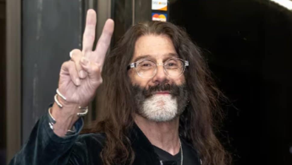 Pierre Robert holds up the peace sign.