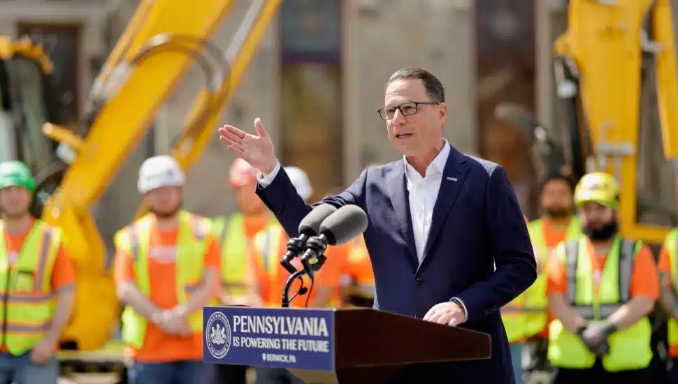Josh Shapiro speaks from a podium at a construction site.