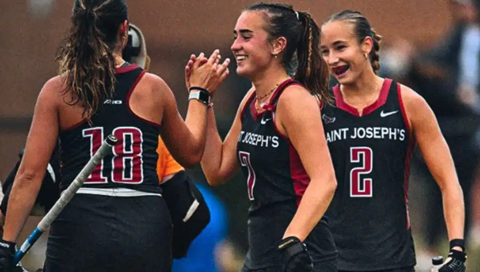 St. Joe's field hockey players celebrate on the field.