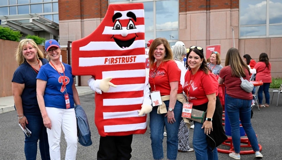 Bank's mascot poses for picture with employees.