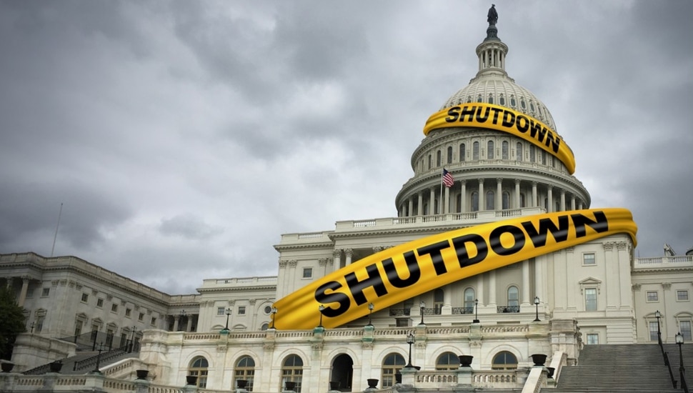 Yellow shutdown caution tape wrapped around capitol building.