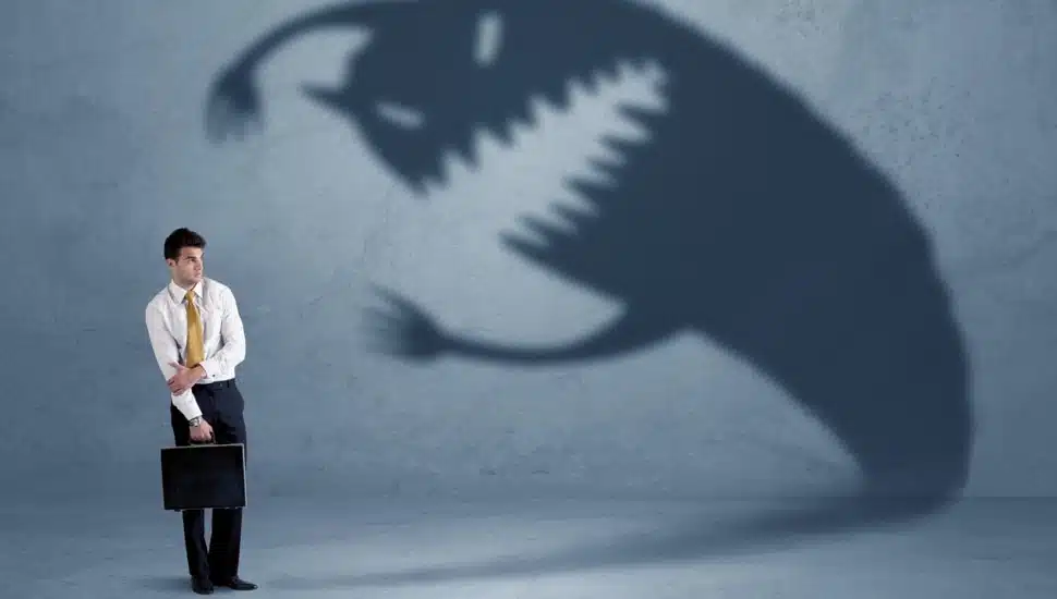 Businessman afraid of his own shadow monster.