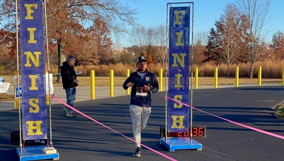 Runner crossing the finish line at 2024 Strive and Thrive Wellness Fest.