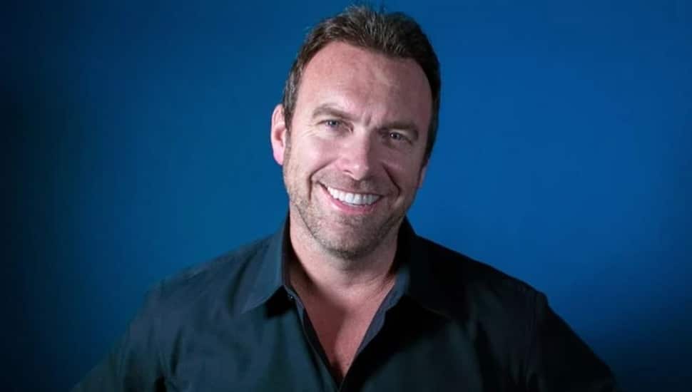 Headshot of middle-aged male in blue-collared shirt.