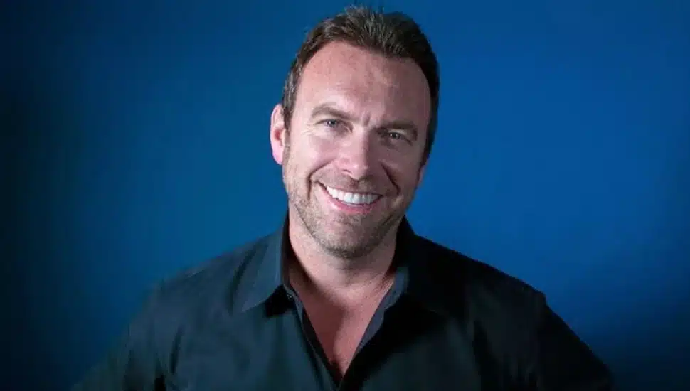 Headshot of middle-aged male in blue-collared shirt.