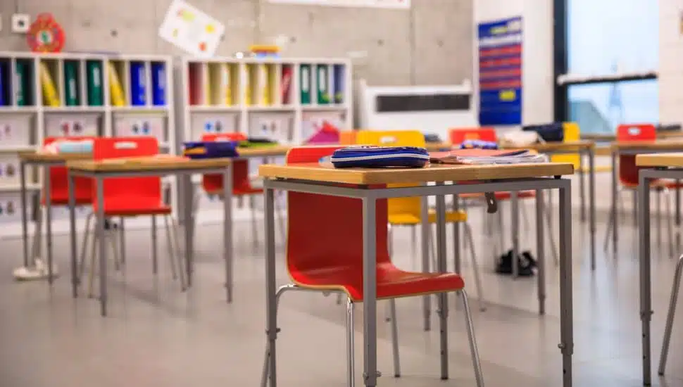 Elementary classroom with desks and chairs.
