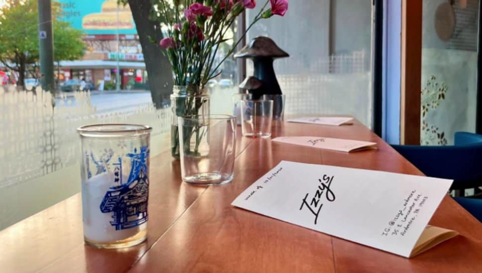 A paper menu sits on a table at Izzy's Cocktail Bar.