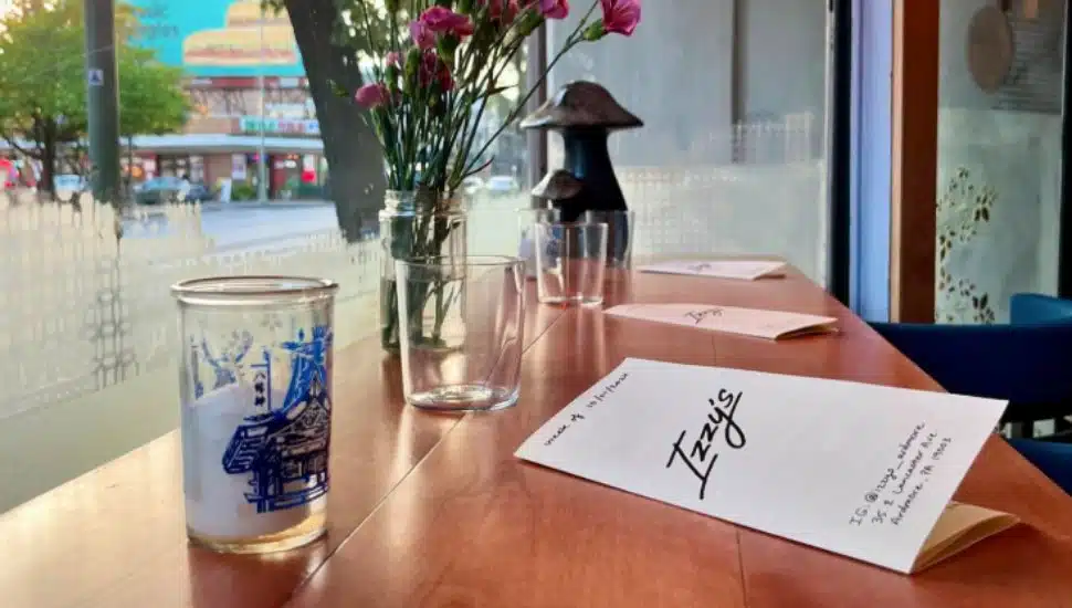 A paper menu sits on a table at Izzy's Cocktail Bar.