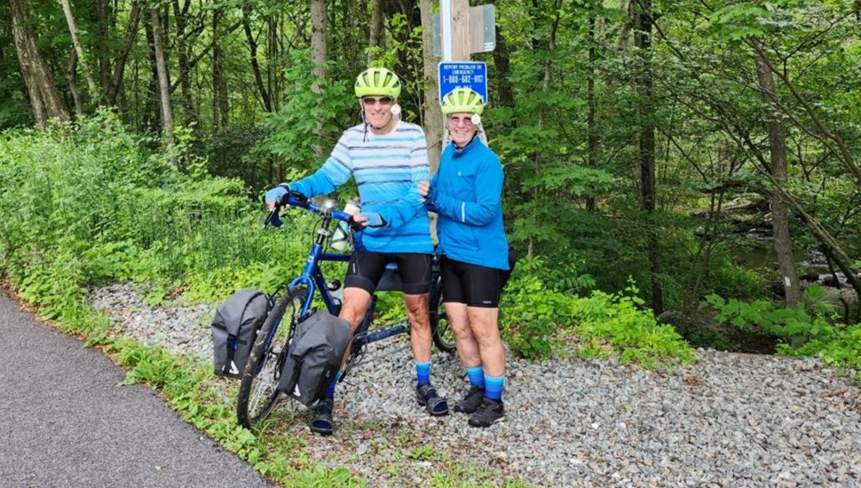 Older couple poses for picture on bike trail.