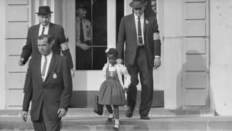 A young Ruby Bridges walks to her newly integrated school by escort.