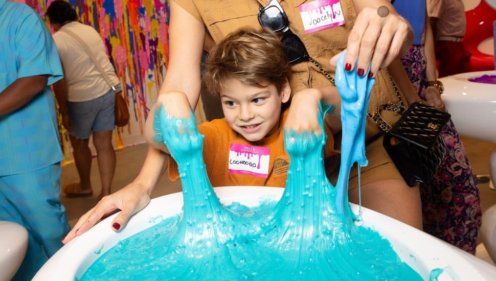 A young boy plays with slime at the Sloomoo Institute.