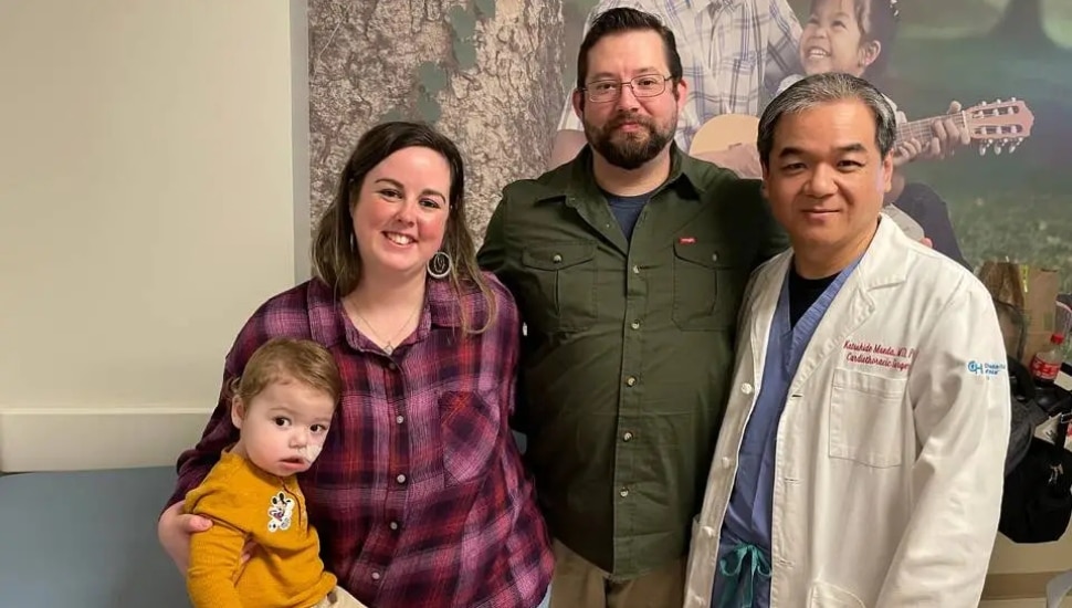 A young boy with his parents and a doctor.