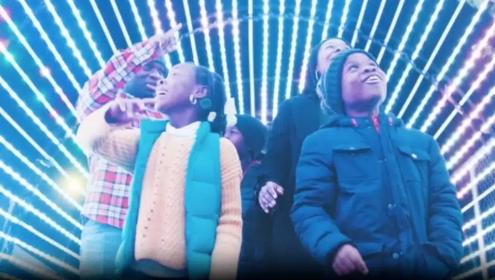 A family walks through a tunnel of lights at the Elmwood Park Zoo.
