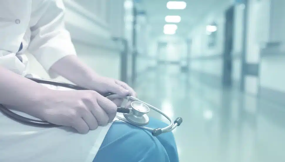 Medical doctor in empty hospital corridor.