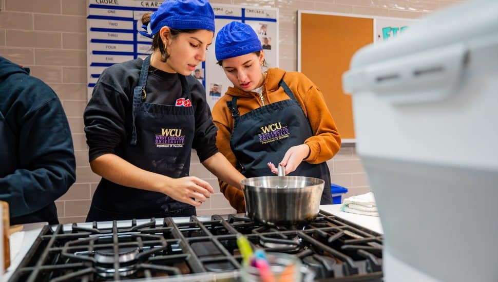 West Chester University nutrition students collaborate in the campus Food Lab, cooking and preparing meals as part of a community service project.