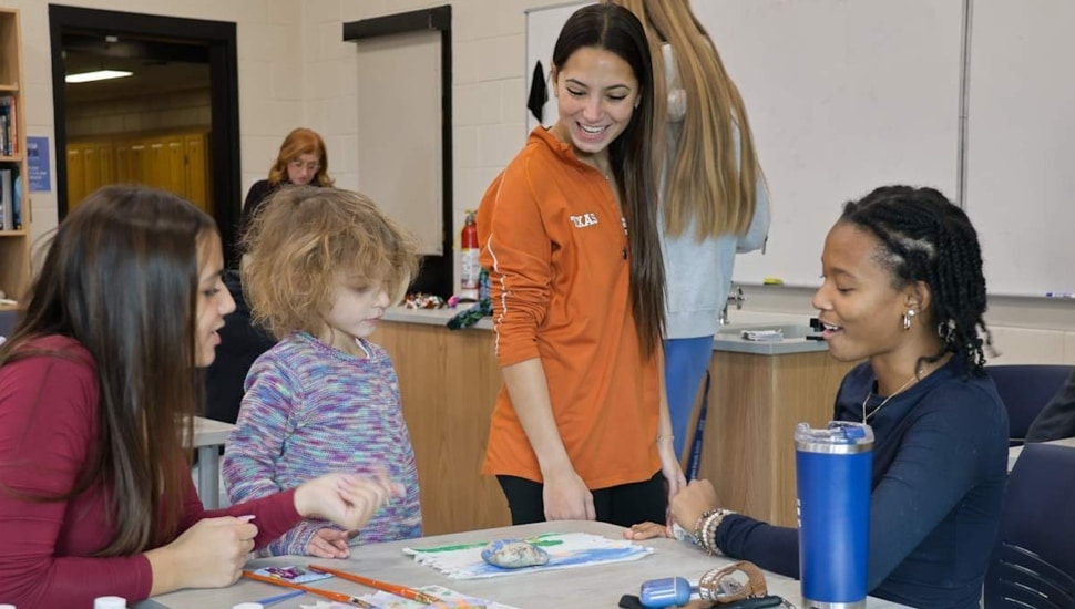 High school students work on art project with kindergarteners.